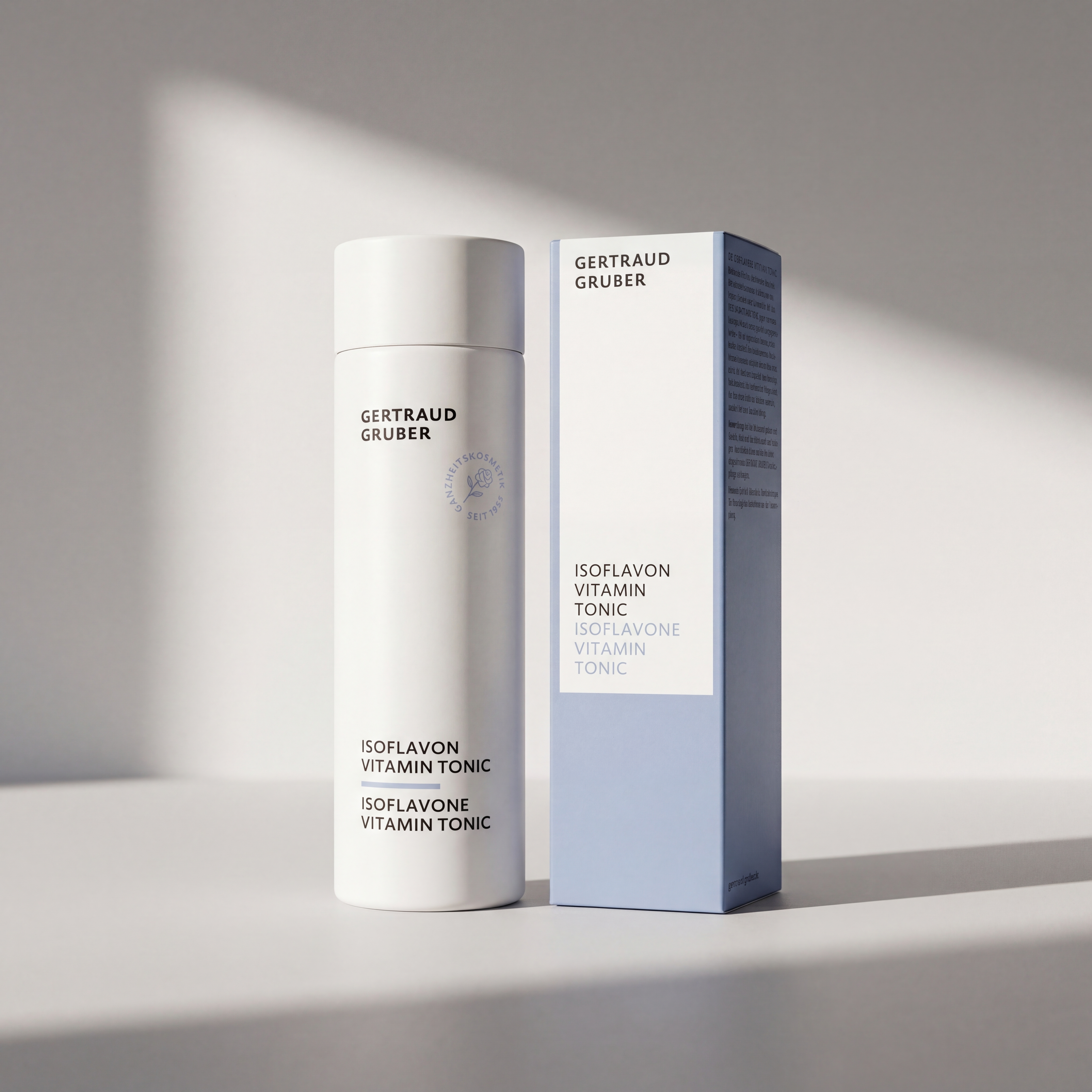 Isoflavon Vitamin Tonic in weißem Spender von Gertraud Gruber Kosmetik vor heller Wand mit blauer Faltschachtel