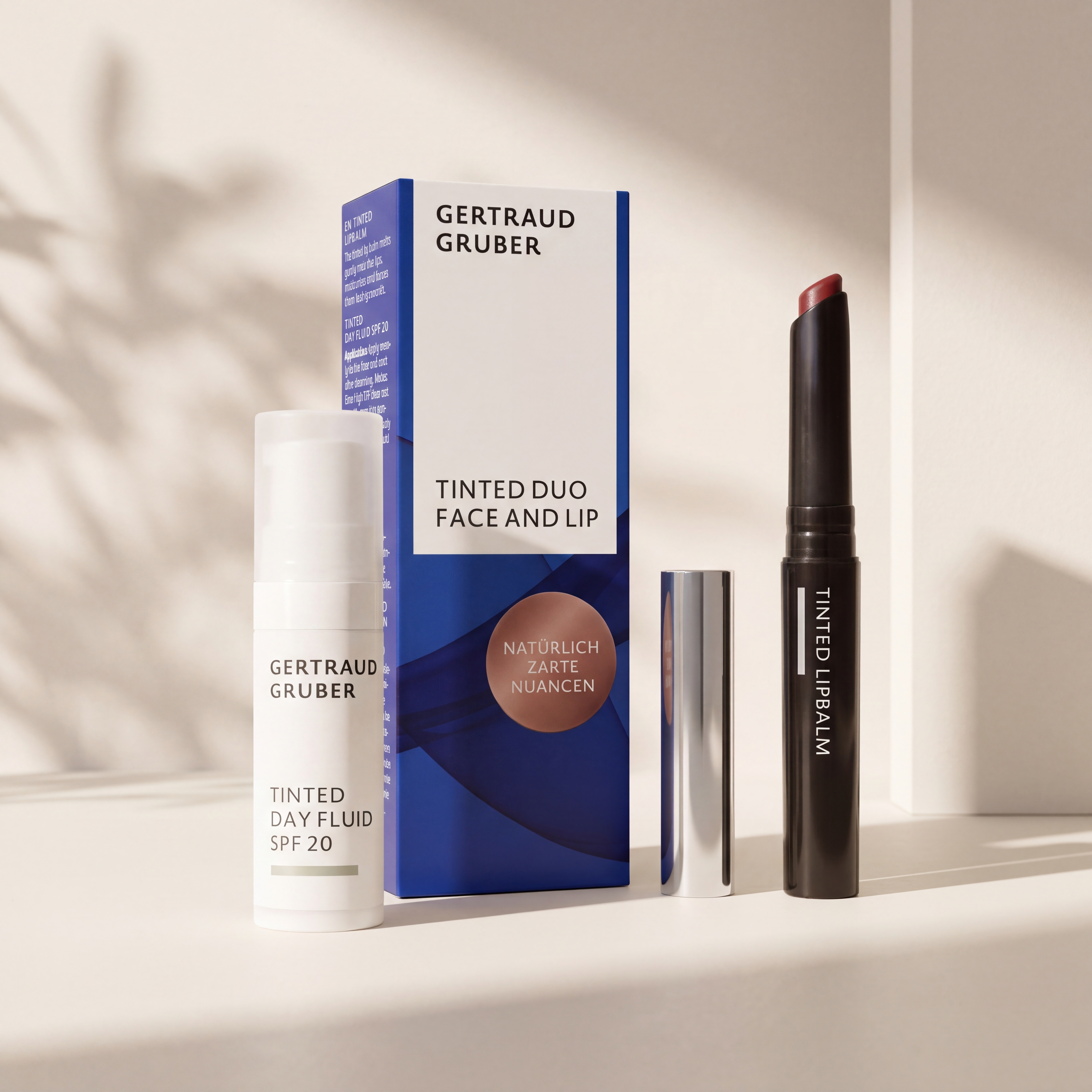 Tinted Duo Face and Lip Set von GERTRAUD GRUBER mit Tinted Day Fluid SPF 20 und Tinted Lipbalm vor der Geschenkverpackung, stilvoll in warmem Licht inszeniert.