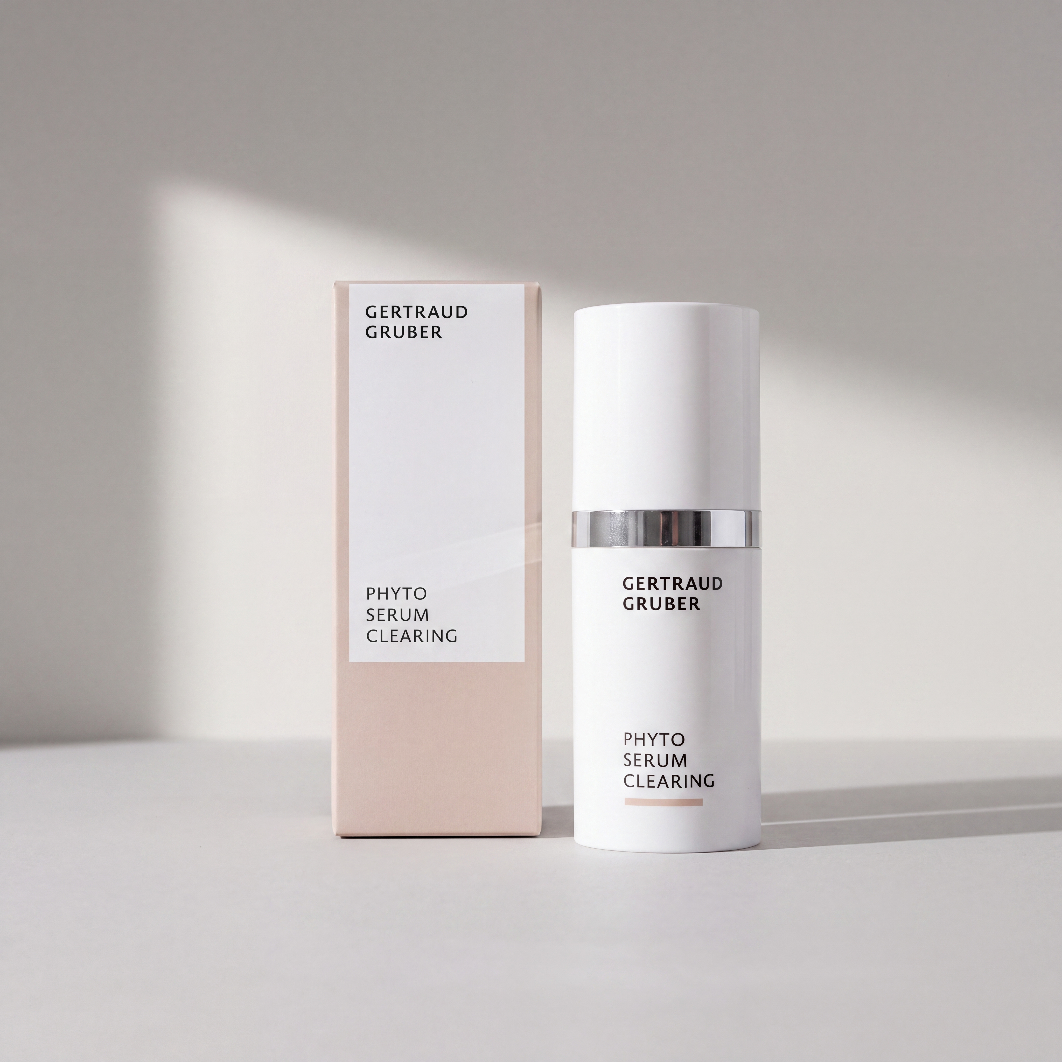 Schlanke weiße Flasche Phyto Serum Clearing mit Faltschachtel von Gertraud Gruber Kosmetik vor heller Wand mit sanften Schatten