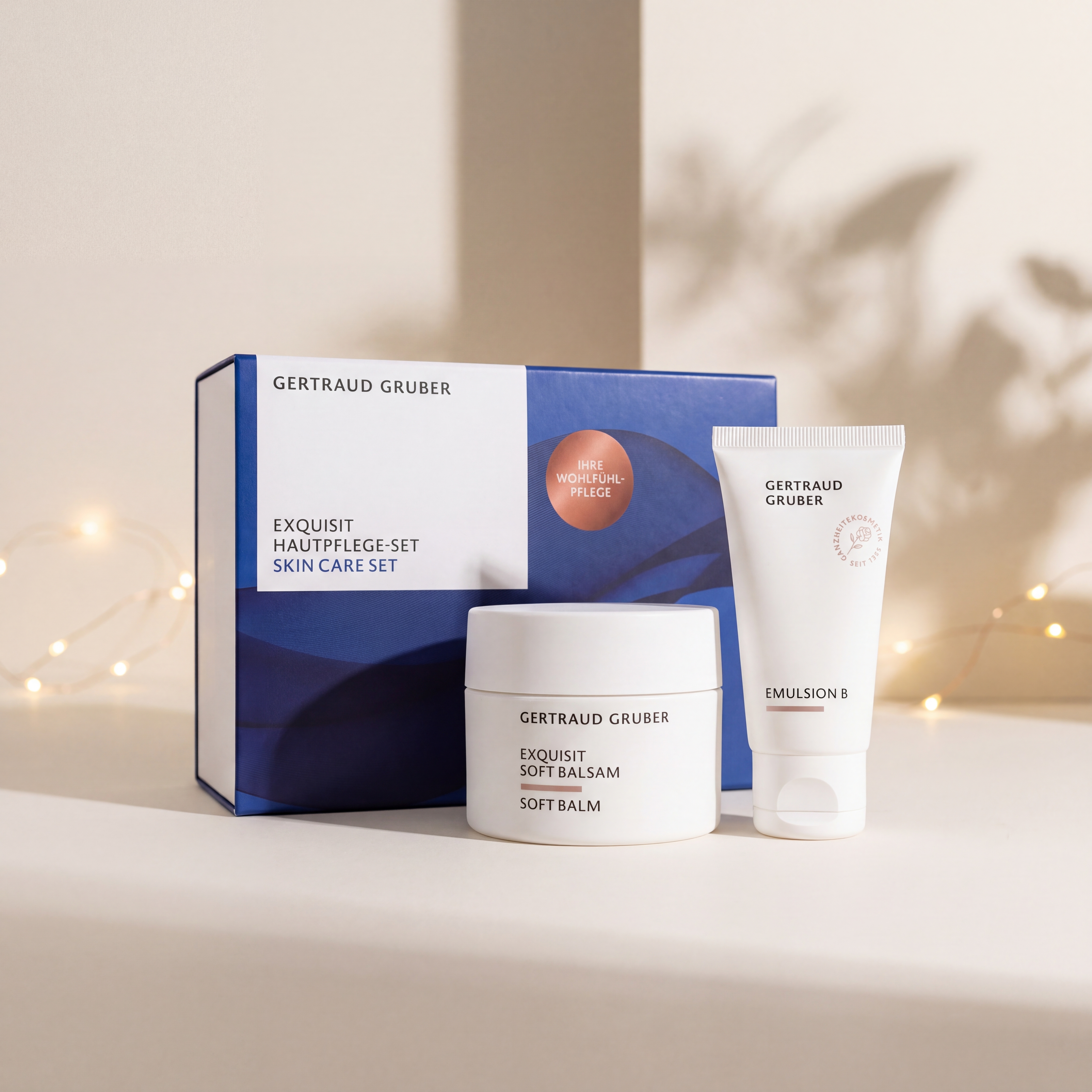 Exquisit Hautpflege-Set von GERTRAUD GRUBER mit Exquisit Soft Balsam und Emulsion B vor der Geschenkverpackung, stimmungsvoll inszeniert mit warmen Lichtern.