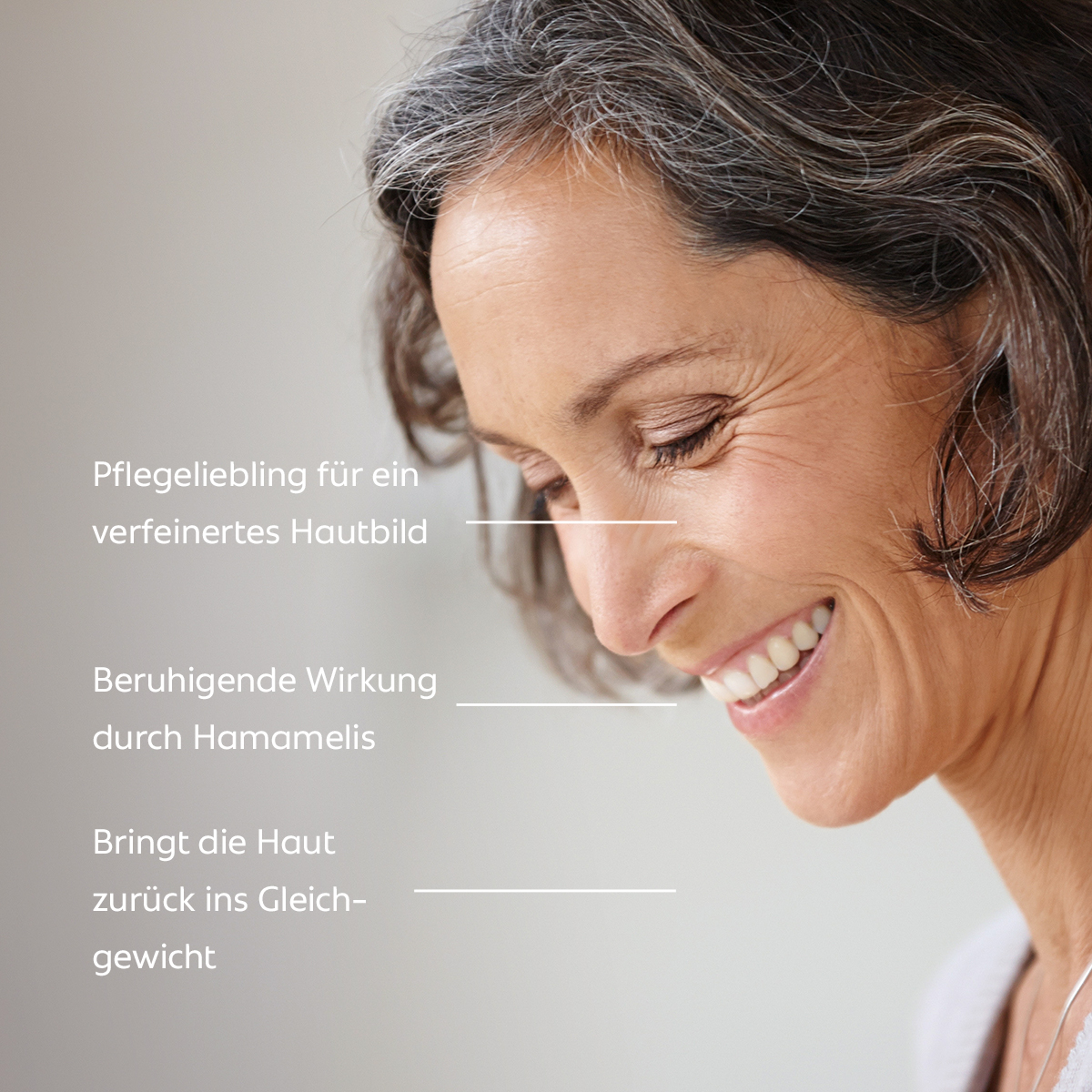 Eine lächelnde Frau mit reifer Haut blickt nach unten; der Text beschreibt: verfeinert das Hautbild, wirkt beruhigend und bringt die Haut ins Gleichgewicht.