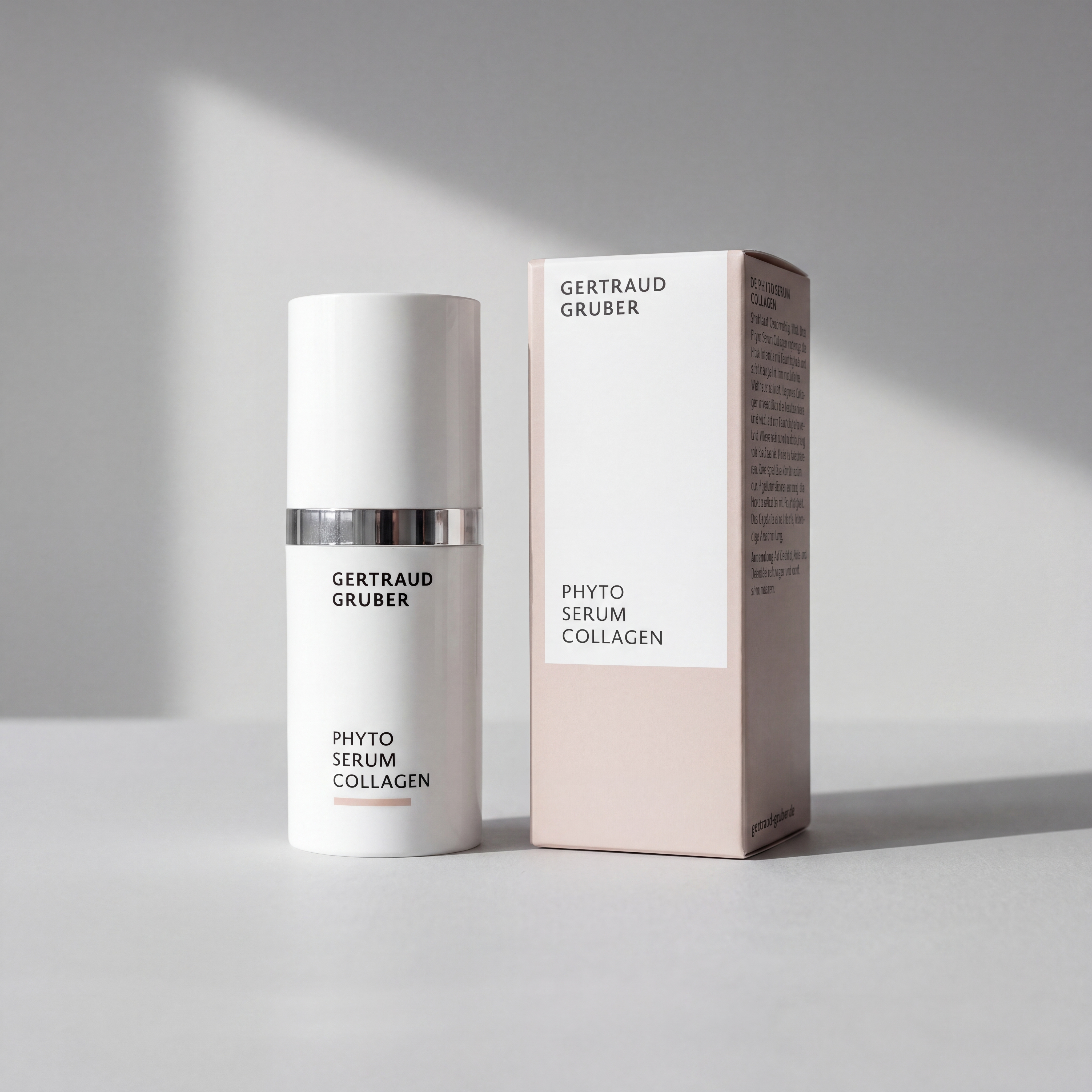 Schlanke weiße Flasche Phyto Serum Collagen mit Faltschachtel von Gertraud Gruber Kosmetik vor heller Wand mit sanften Schatten