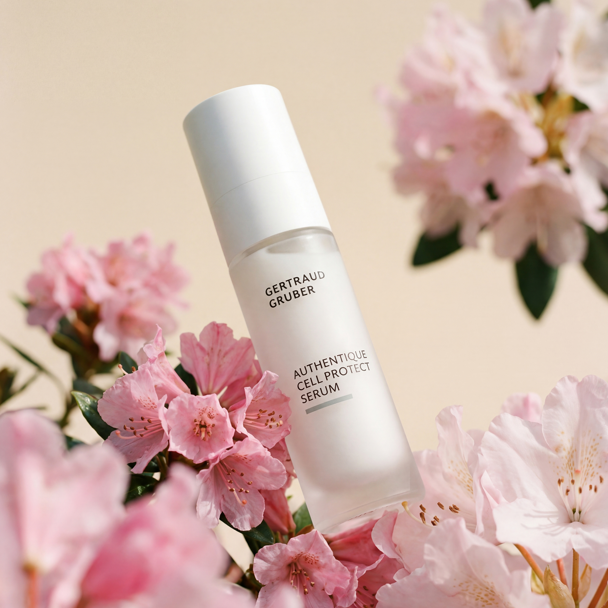 Edle Glasflasche Authentique Cell Protect Serum von Gertraud Gruber Kosmetik  mit blumigem Hintergrund