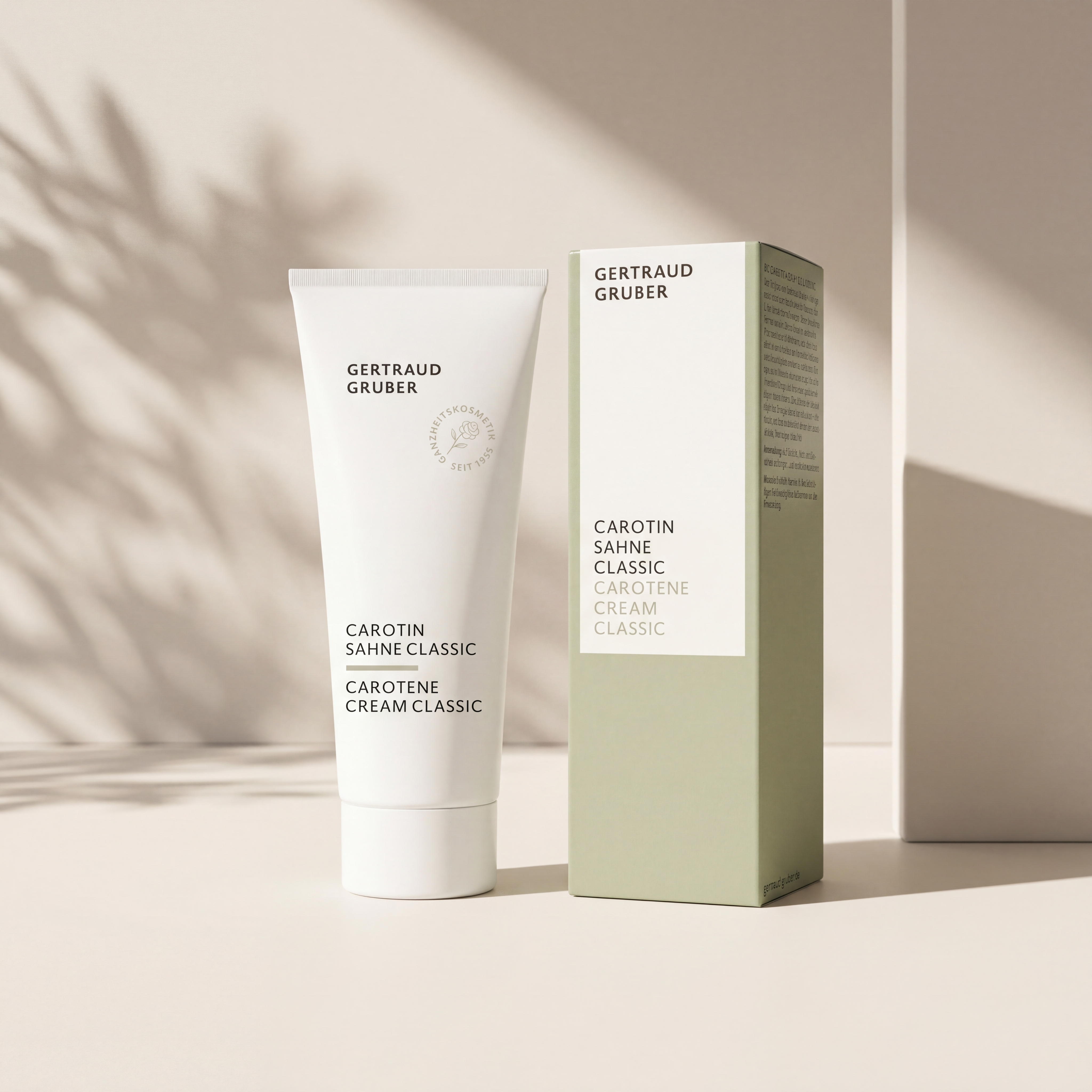 Weiße Tube Carotin Sahne Classic von Gertraud Gruber Kosmetik vor ruhigem, lichtdurchflutetem Hintergrund mit grüner Faltschachtel