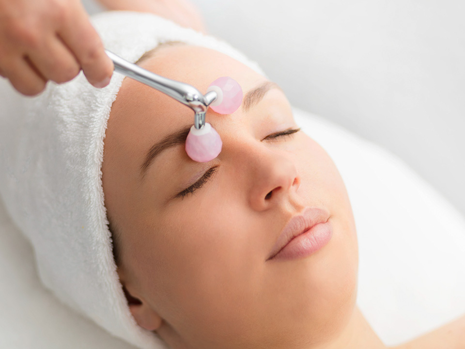 Eine Kosmetikbehandlung mit einem Rosenquarzroller