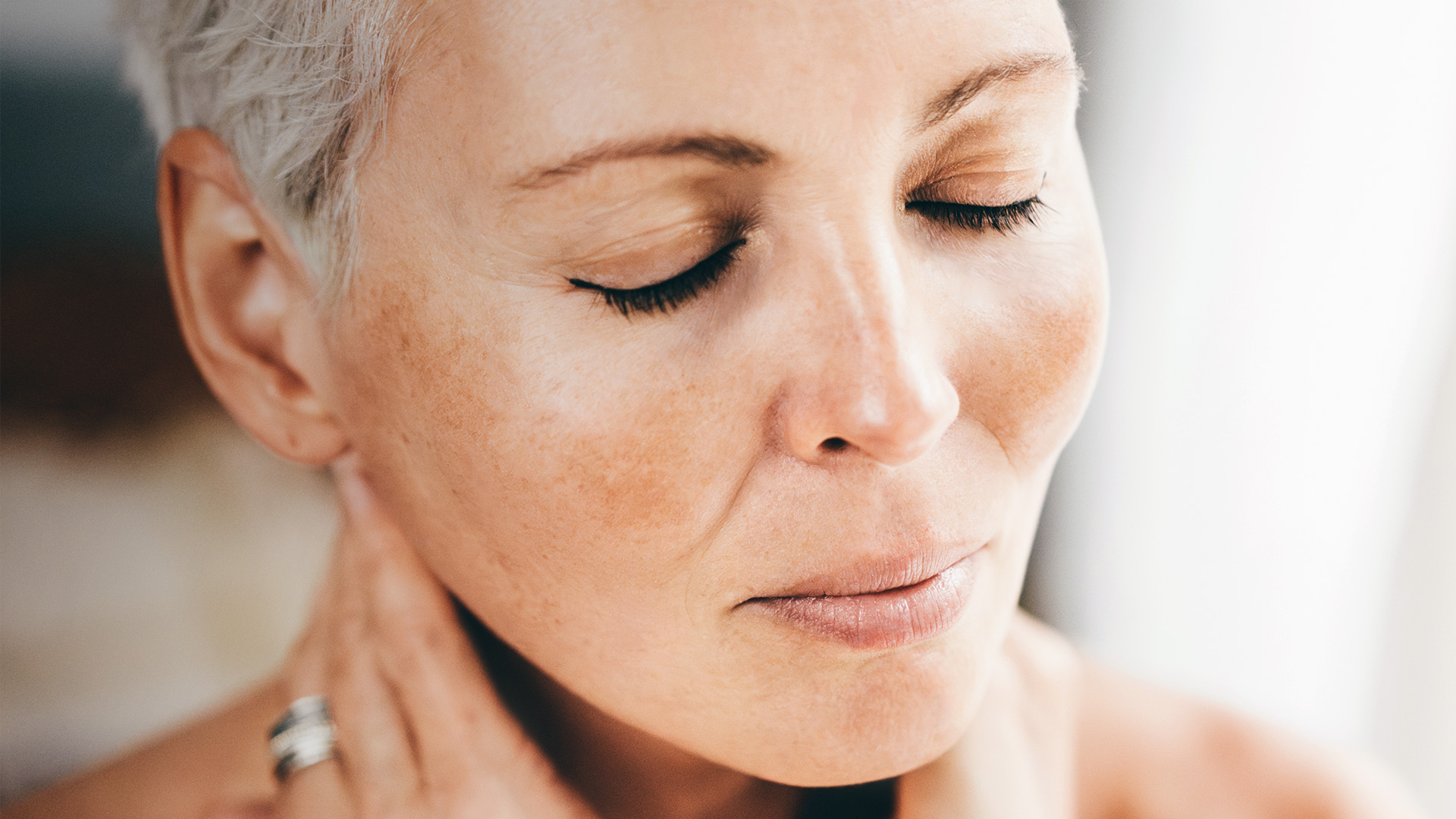 Frau mit grauen Haaren und geschlossenen Augen