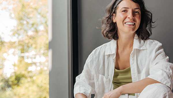 Natürlich lächelnde Frau mit frischer, gepflegter Haut