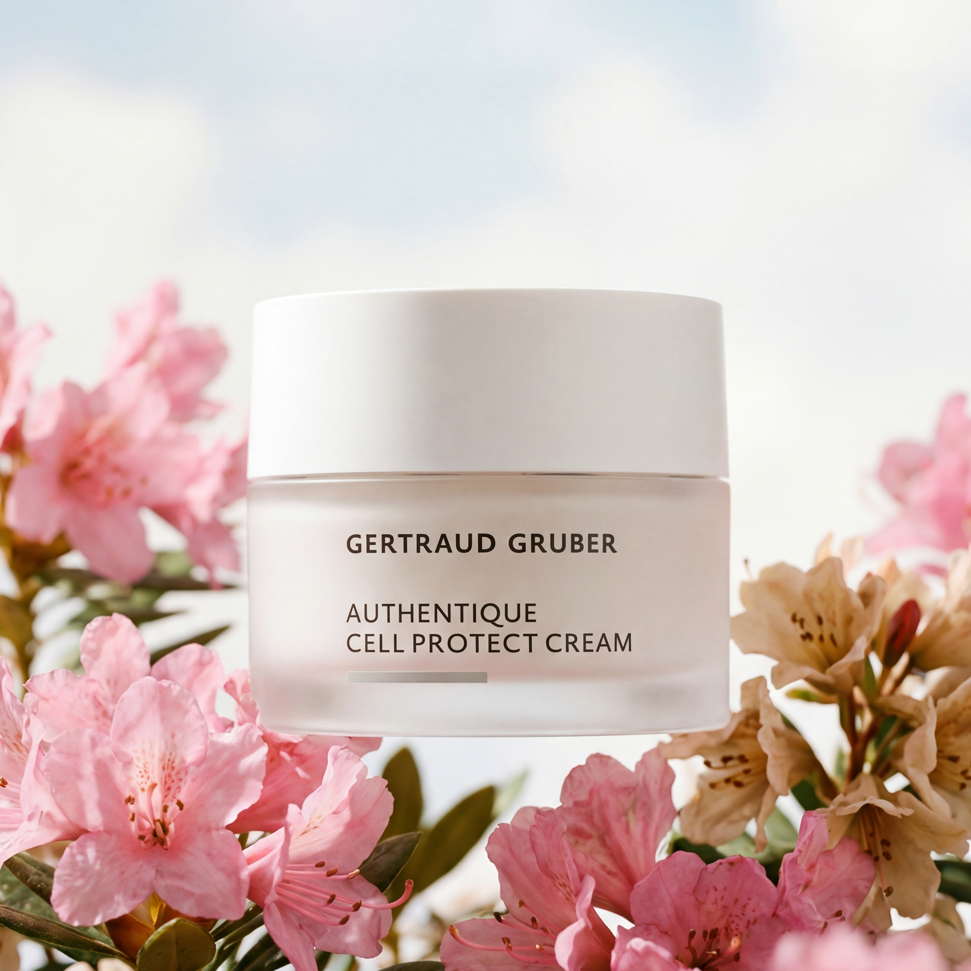 Edler Glastiegel Authentique Cell Protect Creme von Gertraud Gruber Kosmetik vor blumigem Hintergrund