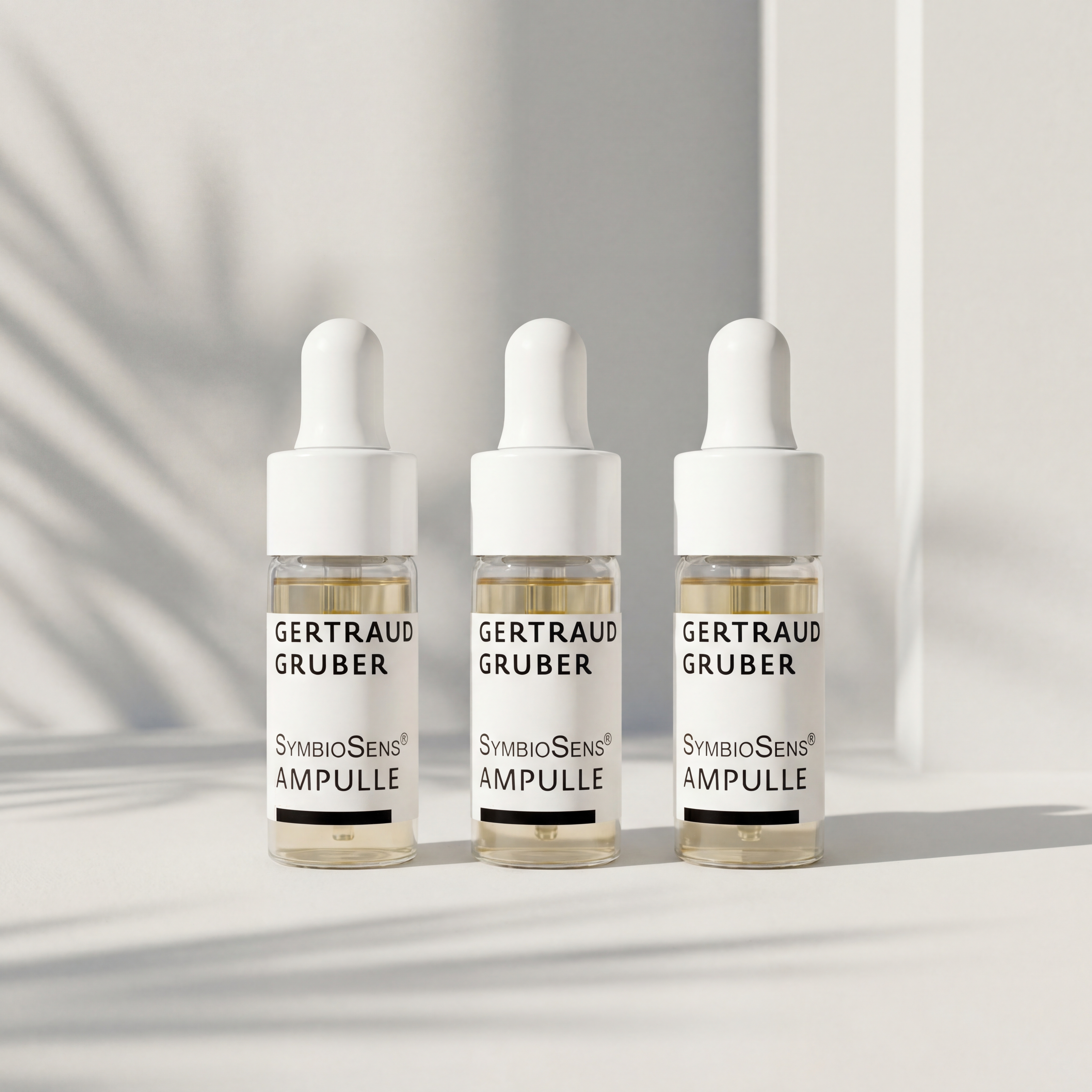Drei SymbioSens Ampullen von Gertraud Gruber Kosmetik in Glasfläschchen mit Pipette vor heller Wand