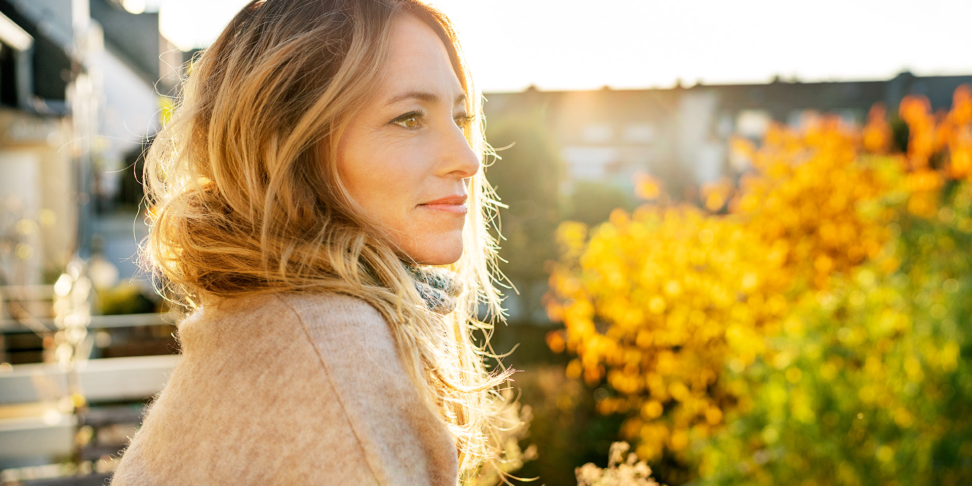 Eine Frau im Gegenlicht schaut in die Ferne.